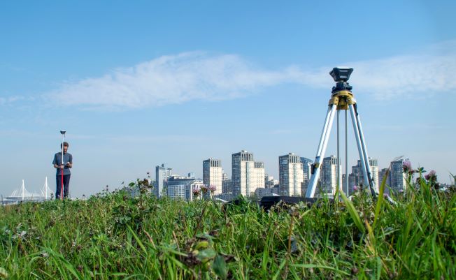 A surveyor taking measurements in a field